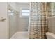 Bathroom featuring a tub and shower with a neutral-toned shower curtain and tiled walls at 3514 Truman Dr, Holiday, FL 34691