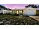 This charming home boasts a covered porch, an attached garage, and curb appeal with colorful skies in the background at 3514 Truman Dr, Holiday, FL 34691