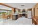 Open kitchen with modern appliances, tile floors, and seamless flow to the adjacent dining area at 3514 Truman Dr, Holiday, FL 34691