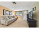 Bright living room with a comfortable sofa, television, and a view of the front yard at 3514 Truman Dr, Holiday, FL 34691