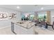Open kitchen with stainless steel dishwasher, granite countertops, and views of the living room and dining area at 35676 Lockman Way, Zephyrhills, FL 33541
