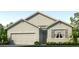 Charming single-story home featuring a two-car garage and landscaped front yard at 35687 Lockman Way, Zephyrhills, FL 33541