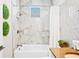 Elegant bathroom features a bathtub, shower, marble tile, modern fixtures, and vanity with plants, creating a spa-like retreat at 4405 Barletta Ct, Wesley Chapel, FL 33543