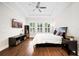 A bright bedroom featuring a large window with shutters, a ceiling fan and wood-look floors at 4405 Barletta Ct, Wesley Chapel, FL 33543