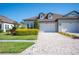 Charming townhome with a two-car garage, stone accents, and a well-maintained brick driveway and landscape at 4405 Barletta Ct, Wesley Chapel, FL 33543