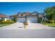 Beautiful townhome with stone accents, two-car garage, dormer windows and landscaped front yard with brick paver driveway at 4405 Barletta Ct, Wesley Chapel, FL 33543