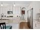 Well appointed kitchen features white cabinetry, stainless appliances, granite counters, and an arched doorway at 4405 Barletta Ct, Wesley Chapel, FL 33543