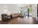 Bright living room featuring floor-to-ceiling windows, hardwood flooring, and contemporary furniture at 4405 Barletta Ct, Wesley Chapel, FL 33543
