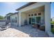 Spacious covered patio with outdoor seating, brick floors, hanging swing, and inviting atmosphere for relaxation and entertaining at 4405 Barletta Ct, Wesley Chapel, FL 33543