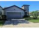 Charming home with a two-car garage, well-kept lawn and stone column feature at 5154 Brickwood Rise Dr, Wimauma, FL 33598