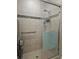 Modern tiled shower with grab bar and glass enclosure at 5154 Brickwood Rise Dr, Wimauma, FL 33598