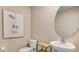 Simple half bathroom features toilet, sink with large mirror and artistic wall decor at 5527 Warrington Town Path, Wesley Chapel, FL 33545