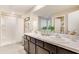 Bathroom with double vanity, sleek countertops, and a shower with a white shower curtain at 5527 Warrington Town Path, Wesley Chapel, FL 33545