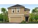 Two-story home with a two-car garage, stucco siding, and well-manicured landscaping at 5527 Warrington Town Path, Wesley Chapel, FL 33545