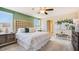 Bedroom with an upholstered headboard, accent wall, and neutral-toned bedding at 5527 Warrington Town Path, Wesley Chapel, FL 33545