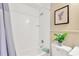 Well-lit bathtub featuring white tile and a shower curtain, complemented by stylish wainscotting and a plant at 602 Stephens Rd, Ruskin, FL 33570