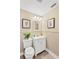 Compact half-bathroom with wooden floors, wainscotting, and a white sink and toilet at 602 Stephens Rd, Ruskin, FL 33570