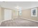 Bright bedroom features plush carpeting, neutral paint, and ample natural light from two windows at 602 Stephens Rd, Ruskin, FL 33570