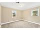 A cozy bedroom with neutral walls, two sunny windows, and plush carpet flooring at 602 Stephens Rd, Ruskin, FL 33570