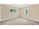 Cozy bedroom with carpeted floors, neutral walls, and two windows offering natural light and outdoor views at 602 Stephens Rd, Ruskin, FL 33570