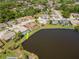 Aerial view of a house with pool on lake in a residential neighborhood at 6056 Fall River Dr, New Port Richey, FL 34655