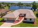 An aerial view shows the home's backyard with beautiful water view, and an attached two-car garage at 6056 Fall River Dr, New Port Richey, FL 34655