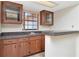 Bar area featuring wood cabinets, tile floors, and a window for natural light at 6056 Fall River Dr, New Port Richey, FL 34655