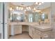 Bathroom featuring double sinks, a large mirror, and a glass block shower with decorative glass window at 6056 Fall River Dr, New Port Richey, FL 34655