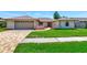 Charming single-story home boasting a manicured lawn, brick driveway, and attached two-car garage at 6056 Fall River Dr, New Port Richey, FL 34655