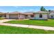 Charming single-story home features a well-manicured lawn, inviting walkway, and attached two-car garage at 6056 Fall River Dr, New Port Richey, FL 34655