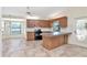 Kitchen and dining area featuring tile floors and wooden cabinets with a breakfast bar at 6056 Fall River Dr, New Port Richey, FL 34655