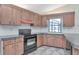 Kitchen featuring black appliances, tiled backsplash, and wood cabinets at 6056 Fall River Dr, New Port Richey, FL 34655