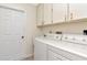 Functional laundry room with sink, storage cabinets, washer, and dryer at 6056 Fall River Dr, New Port Richey, FL 34655