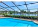 In-ground swimming pool with screened enclosure showcasing a lovely lake view at 6056 Fall River Dr, New Port Richey, FL 34655