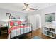 Cozy bedroom with hardwood floors, ceiling fan, and a view from the window at 636 16Th Ne Ave, St Petersburg, FL 33704