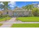 Well-maintained home featuring a freshly cut lawn, complemented by flourishing tropical plants and palm trees at 636 16Th Ne Ave, St Petersburg, FL 33704