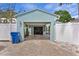 Garage exterior showcasing a light blue paint job, well maintained white fence, and a brick driveway at 636 16Th Ne Ave, St Petersburg, FL 33704