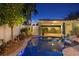 Backyard pool featuring lovely landscaping and an illuminated pool in the nighttime at 636 16Th Ne Ave, St Petersburg, FL 33704