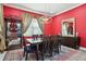 Inviting dining room featuring red walls, a wooden table with seating for six, and neutral decor at 714 S Lois Ave, Tampa, FL 33609