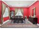 Elegant dining room featuring rich red walls, a large wooden table, and striking gold drapes at 714 S Lois Ave, Tampa, FL 33609