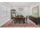 Dining room features a dark wood table, ornate area rug, display cabinet, and bright natural light at 714 S Lois Ave, Tampa, FL 33609