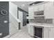 Bright hallway featuring white cabinets, wine cooler, and tiled backsplash adjacent to the staircase and entrance to other rooms at 714 S Lois Ave, Tampa, FL 33609