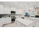 Modern kitchen with white cabinetry, stainless steel appliances, and a center island with quartz countertops at 714 S Lois Ave, Tampa, FL 33609