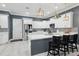 Stylish kitchen featuring a central island with bar seating, pendant lights, stainless appliances, and white shaker cabinets at 714 S Lois Ave, Tampa, FL 33609