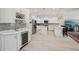 Bright kitchen with stainless appliances, white cabinets, an island, barstool seating, and glass backsplash at 714 S Lois Ave, Tampa, FL 33609