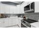 Modern kitchen with stainless steel appliances, sleek cooktop, white countertops, and shaker cabinets at 714 S Lois Ave, Tampa, FL 33609