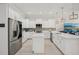 Spacious kitchen with stainless appliances, white cabinets, center island, and stylish pendant lighting at 714 S Lois Ave, Tampa, FL 33609
