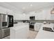 Bright kitchen with stainless steel appliances, white cabinets, an island, and decorative tile backsplash at 714 S Lois Ave, Tampa, FL 33609