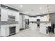 Modern kitchen with stainless steel appliances, sleek white cabinetry, and gray backsplash tiling at 714 S Lois Ave, Tampa, FL 33609