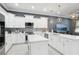 Contemporary kitchen featuring an island, stainless steel appliances, and white cabinets under recessed and pendant lighting at 714 S Lois Ave, Tampa, FL 33609